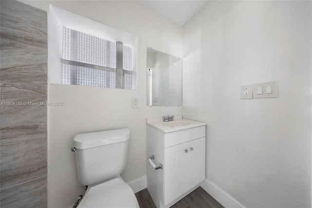 bathroom featuring baseboards, toilet, vanity, and wood finished floors