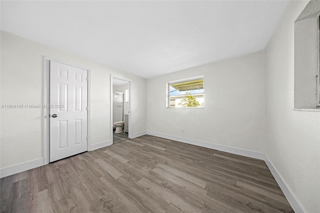 unfurnished bedroom with wood finished floors and baseboards