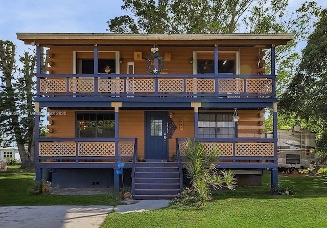 4070 E River Ft, Myers, FL 33916 - view of front of home featuring log siding, a balcony, a porch, and a front lawn