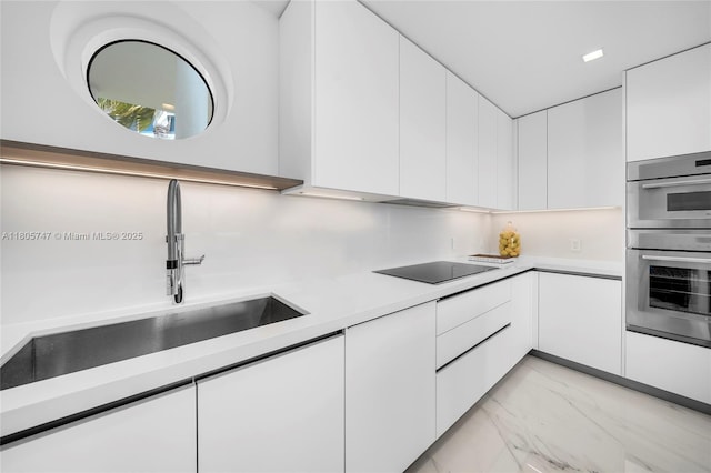 100 S Pointe Dr Unit Th-13, Miami Beach, FL 33139 - kitchen featuring black electric cooktop, light marble finish flooring, white cabinets, light countertops, and modern cabinets