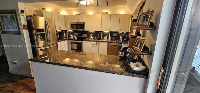 15545 SW 110th Ter, Miami, FL 33196 - kitchen with appliances with stainless steel finishes, a peninsula, dark stone counters, and dark wood-style flooring