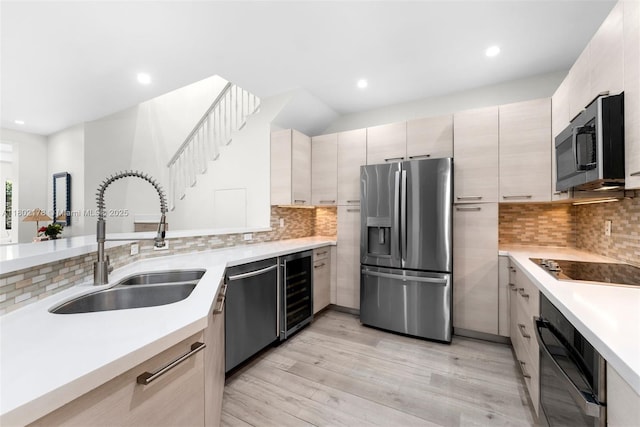 622 Malaga Ave Unit 622, Coral Gables, FL 33134 - kitchen with black appliances, a sink, beverage cooler, light countertops, and light wood finished floors