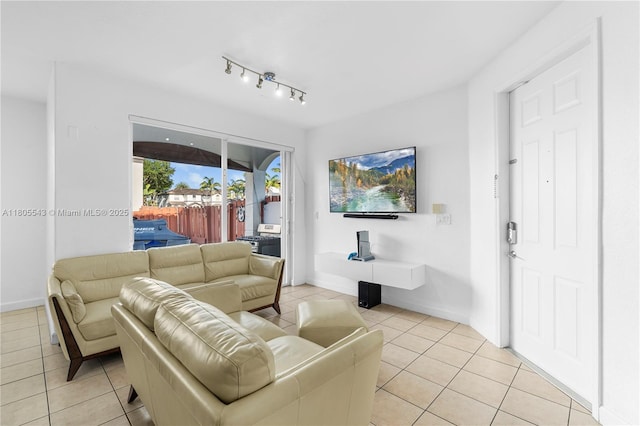 living area with light tile patterned floors, baseboards, and rail lighting