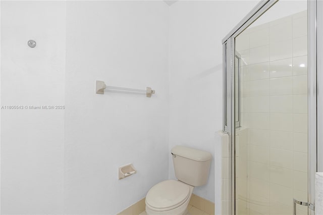 bathroom featuring a stall shower, toilet, baseboards, and tile patterned floors