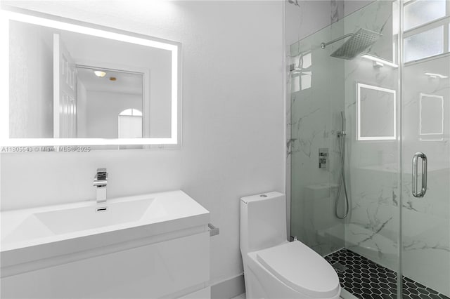 full bath with a marble finish shower, toilet, and vanity