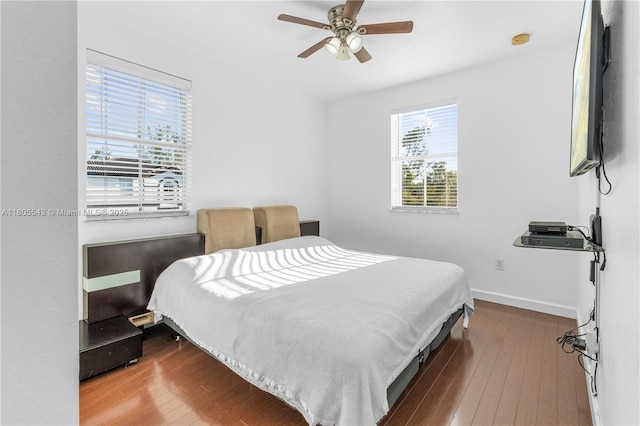 bedroom with wood finished floors, a ceiling fan, and baseboards