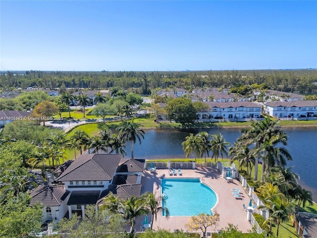aerial view of residential area featuring a pool and a large body of water