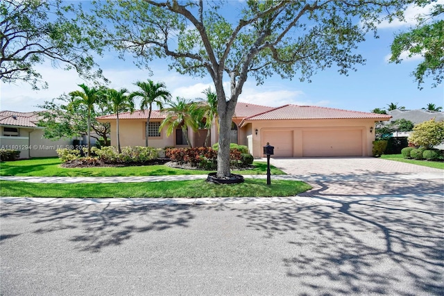 2701 Edgewater Ct, Weston, FL 33332 - view of front of home with a tile roof, driveway, a garage, stucco siding, and a front lawn