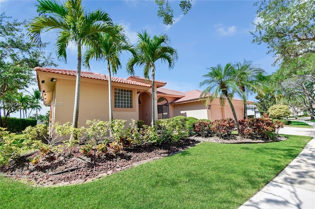 2701 Edgewater Ct, Weston, FL 33332 - mediterranean / spanish home with a front yard, an attached garage, stucco siding, and a tile roof