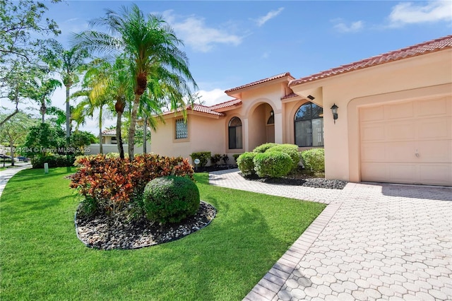 2701 Edgewater Ct, Weston, FL 33332 - mediterranean / spanish house with stucco siding, a front lawn, a tiled roof, a garage, and decorative driveway