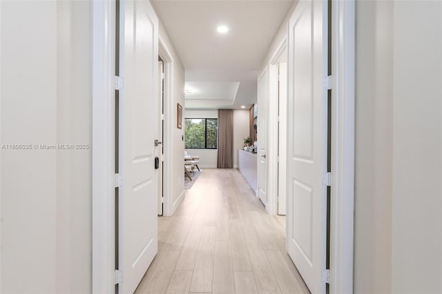 hall with light wood-style flooring, recessed lighting, and baseboards
