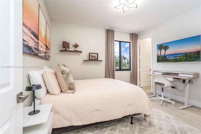bedroom featuring wood finished floors and baseboards