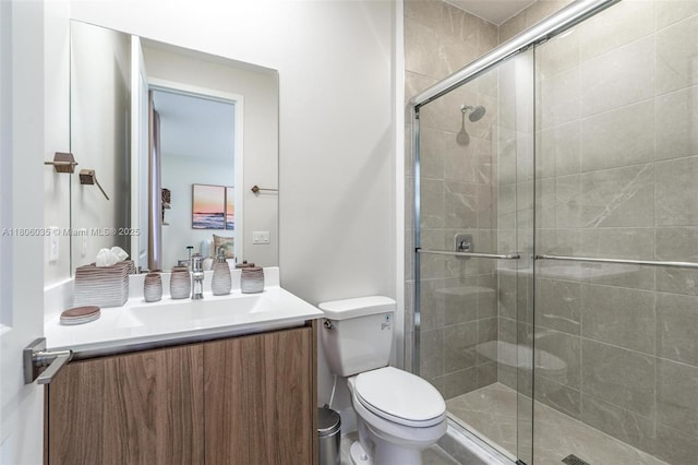 bathroom featuring a stall shower, vanity, and toilet