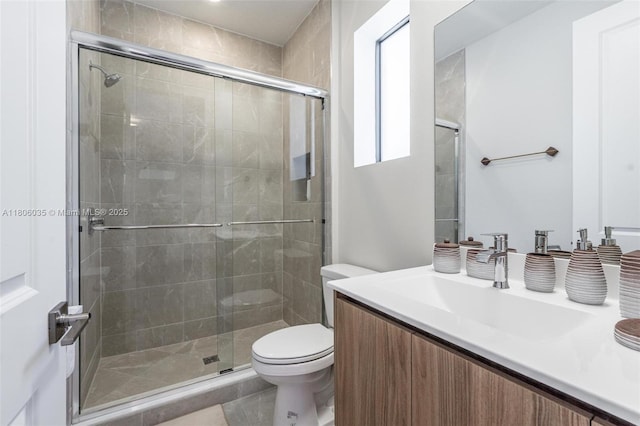 bathroom with toilet, a shower stall, and vanity