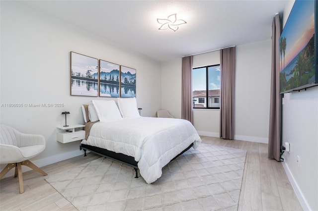 bedroom with light wood-style flooring and baseboards