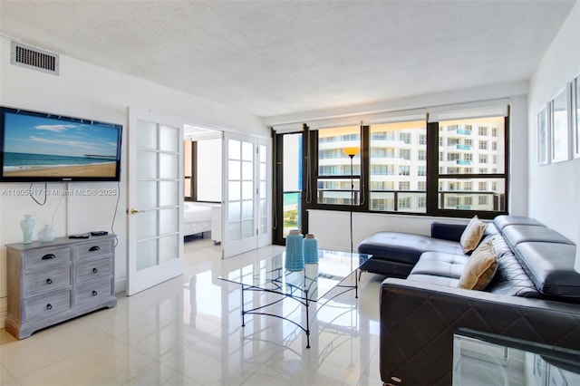 5225 Collins Ave Unit 1409, Miami Beach, FL 33140 - living room with light tile patterned floors, french doors, and a textured ceiling