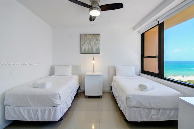 5225 Collins Ave Unit 1409, Miami Beach, FL 33140 - bedroom featuring tile patterned flooring, a water view, baseboards, and a ceiling fan