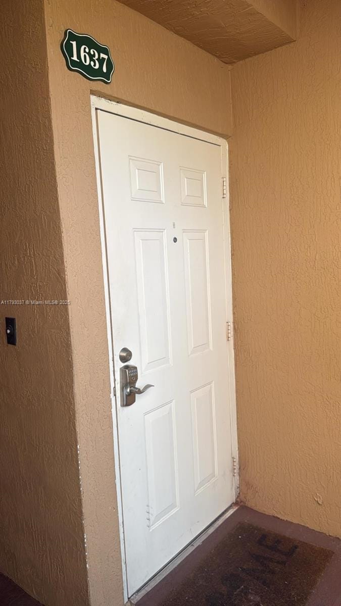 doorway to property featuring stucco siding