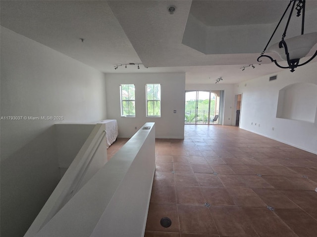 6520 NW 114th Ave Unit 1637, Doral, FL 33178 - tiled spare room featuring track lighting, a pendent fire sprinkler, and baseboards