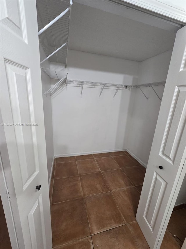 6520 NW 114th Ave Unit 1637, Doral, FL 33178 - walk in closet featuring dark tile patterned floors