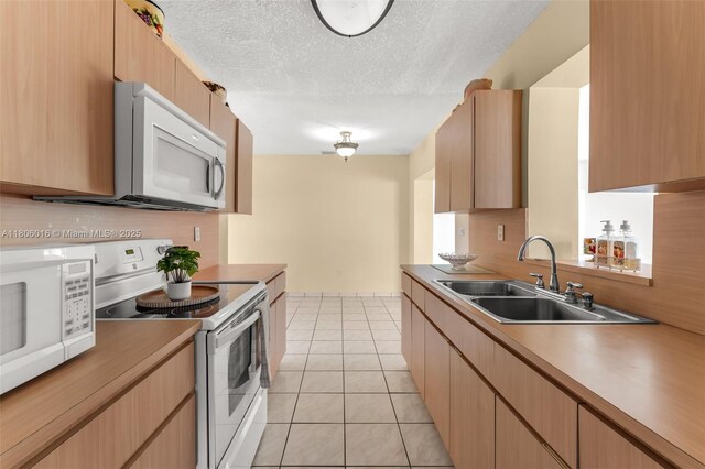 4230 SW 97th Pl, Miami, FL 33165 - kitchen featuring white appliances, a sink, light tile patterned floors, light countertops, and a textured ceiling