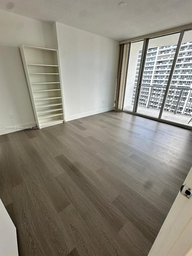 1750 N Bayshore Dr Unit 2906, Miami, FL 33132 - empty room with dark wood finished floors, baseboards, floor to ceiling windows, and a textured ceiling