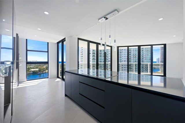 20281 E Country Club Dr Unit 1008, Aventura, FL 33180 - kitchen with modern cabinets, black electric cooktop, hanging light fixtures, light tile patterned floors, and dark cabinets