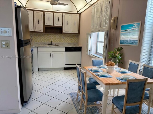 235 E Burgundy E Unit 235, Delray Beach, FL 33484 - kitchen featuring dishwasher, light countertops, backsplash, a sink, and freestanding refrigerator