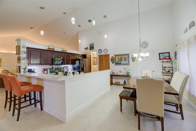 596 NW 164th Ave, Pembroke Pines, FL 33028 - kitchen with refrigerator with ice dispenser, high vaulted ceiling, a chandelier, a kitchen bar, and pendant lighting