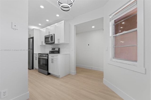 1300 SW 124th Ter Unit 107P, Pembroke Pines, FL 33027 - kitchen with stainless steel appliances, white cabinets, baseboards, light wood-type flooring, and recessed lighting