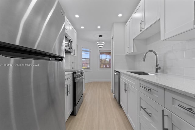 1300 SW 124th Ter Unit 107P, Pembroke Pines, FL 33027 - kitchen with stainless steel appliances, a sink, light wood finished floors, backsplash, and baseboards