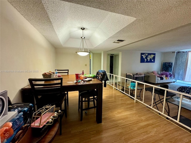 3660 Inverrary Dr Unit 2W, Lauderhill, FL 33319 - dining room featuring a textured ceiling, wood finished floors, and a tray ceiling