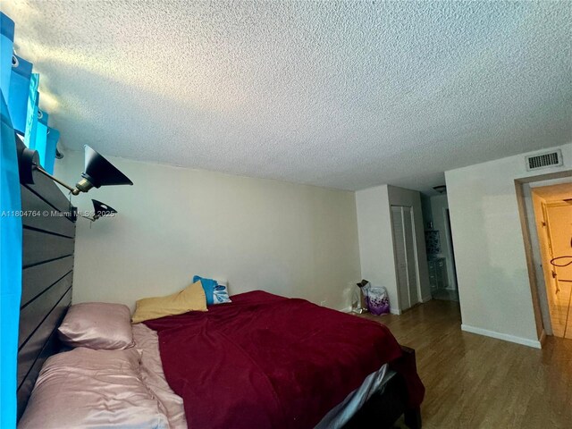 3660 Inverrary Dr Unit 2W, Lauderhill, FL 33319 - bedroom featuring a textured ceiling, wood finished floors, and a closet