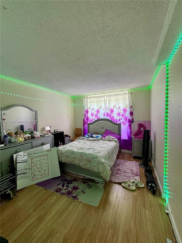 3660 Inverrary Dr Unit 2W, Lauderhill, FL 33319 - bedroom featuring a textured ceiling and wood finished floors
