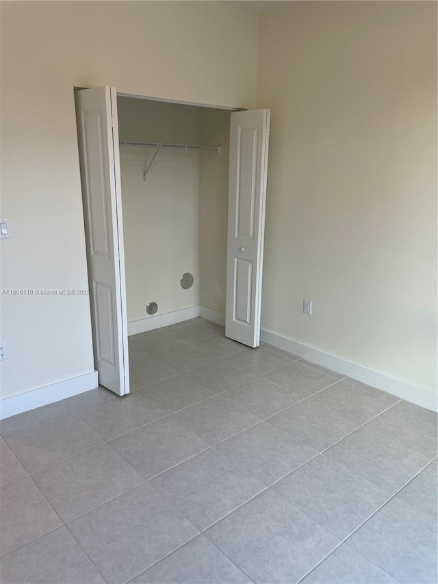 8001NW 41st St Unit F-108, Doral, FL 33166 - unfurnished bedroom featuring light tile patterned floors, a closet, and baseboards
