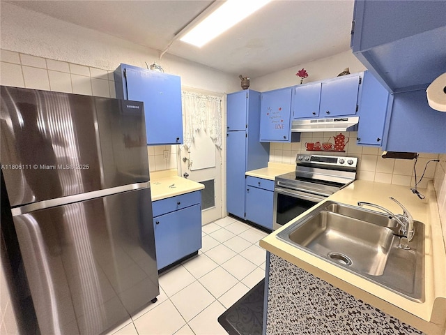 kitchen featuring blue cabinets, stainless steel appliances, under cabinet range hood, a sink, and light tile patterned flooring