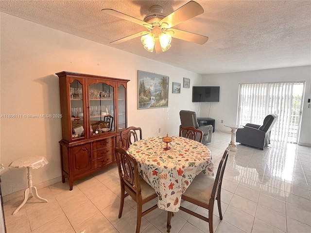 dining room with a textured ceiling, ceiling fan, and light tile patterned floors