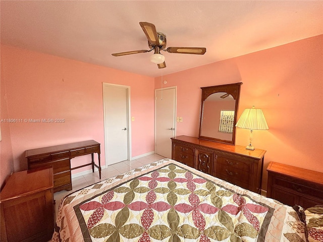 tiled bedroom with ceiling fan and baseboards