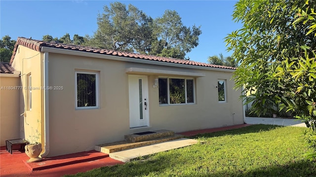 mediterranean / spanish-style home featuring stucco siding, a front lawn, and a tiled roof