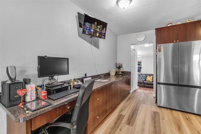 office space with light wood finished floors and a textured ceiling