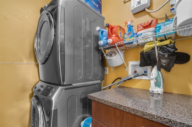 washroom featuring stacked washer and clothes dryer