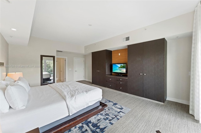 bedroom with light colored carpet and baseboards