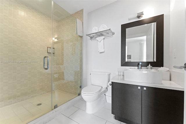 bathroom with tile patterned flooring, a shower stall, toilet, and vanity