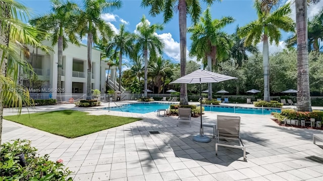 community pool with fence and a patio area
