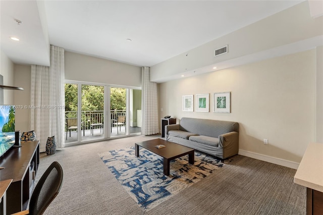 carpeted living area with baseboards and recessed lighting
