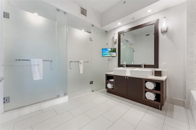bathroom with a shower stall, double vanity, recessed lighting, and tile patterned floors