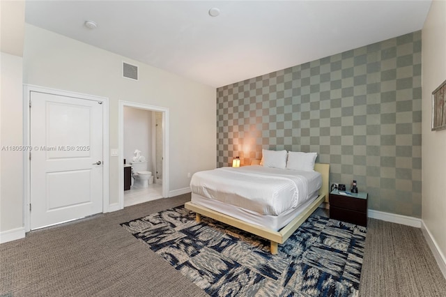 bedroom featuring carpet, an accent wall, baseboards, and ensuite bath