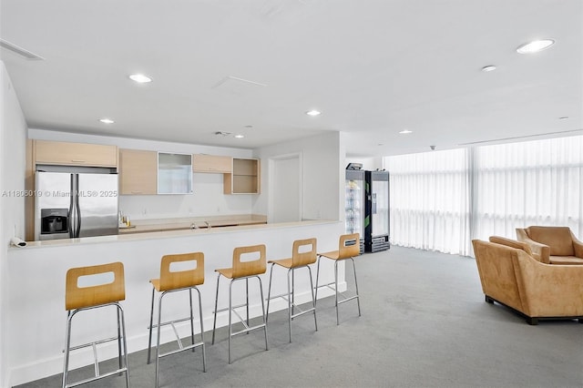 350 NE 24th St Unit 714, Miami, FL 33137 - kitchen with stainless steel fridge with ice dispenser, a kitchen breakfast bar, a peninsula, carpet flooring, and light countertops
