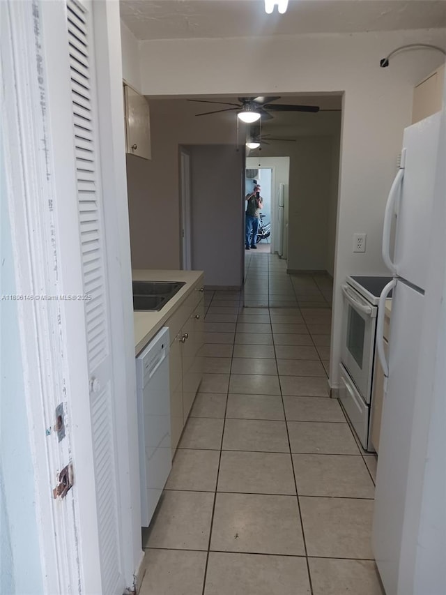 2700 NE 135th St Unit 30, North Miami, FL 33181 - kitchen featuring white appliances, light tile patterned floors, white cabinets, a ceiling fan, and a sink