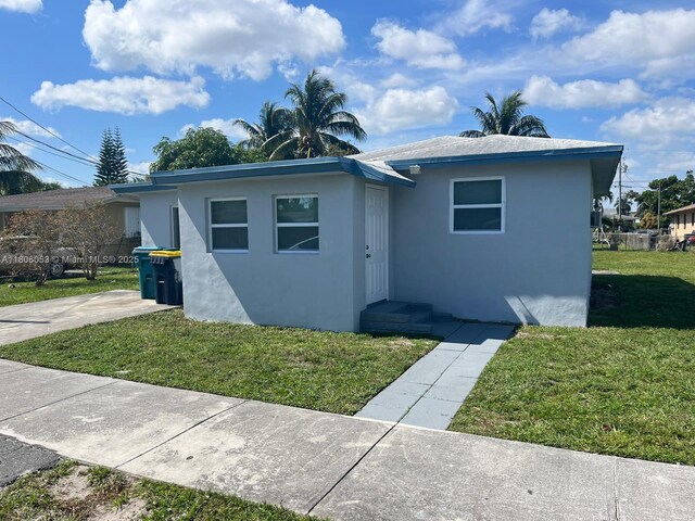 126 NW 13th Ave, Dania Beach, FL 33004 - ranch-style house featuring stucco siding and a front lawn